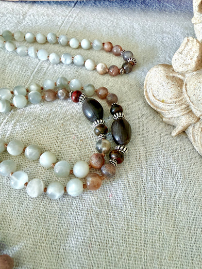 Close-up of Lotus seeds on a  mala necklace with natural gray moonstone from Sri Lanka and black moonstone for meditation