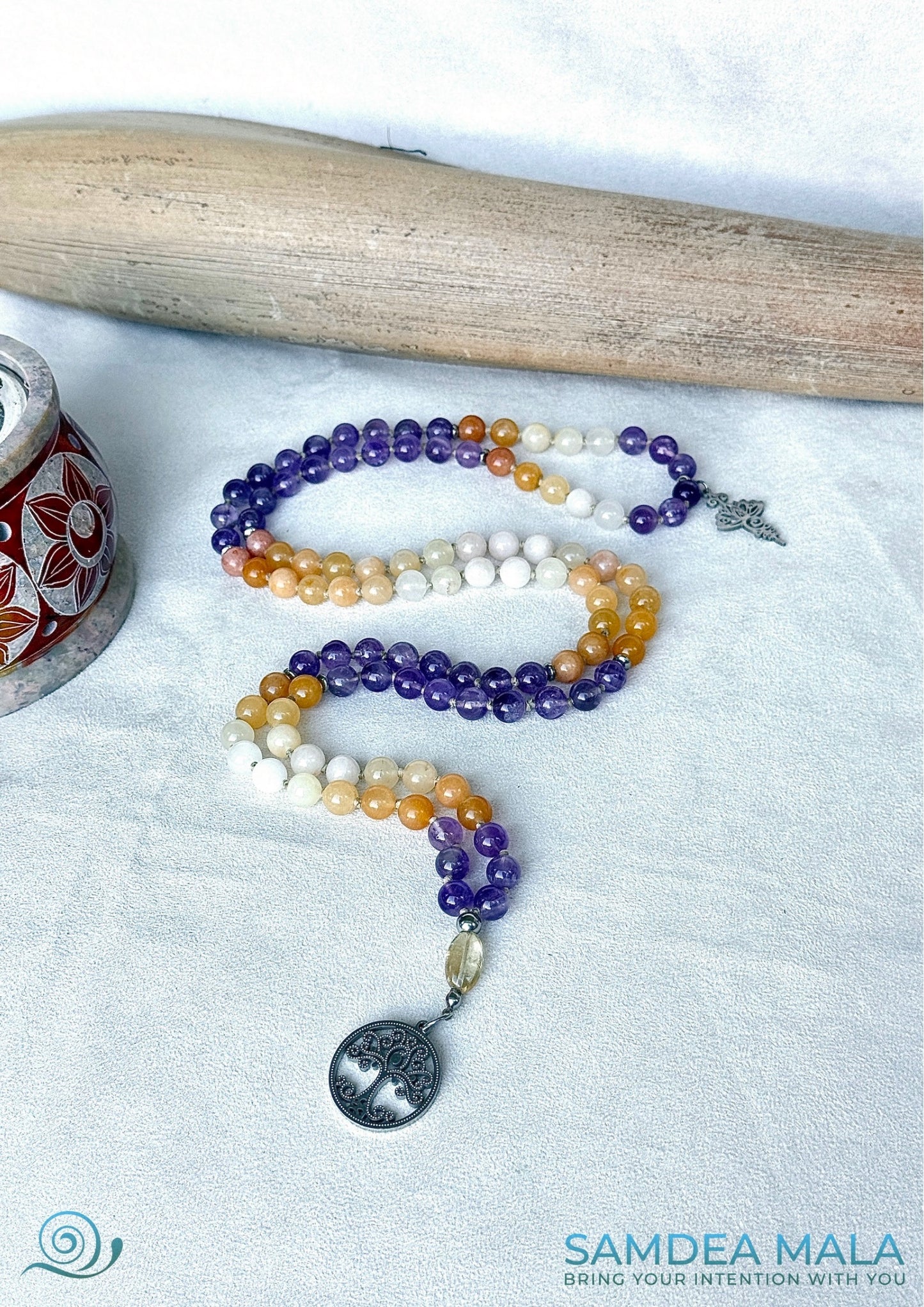 Altar display—mala necklace coiled beside selenite bowl, gemstones for growth and clarity for Sagittarius