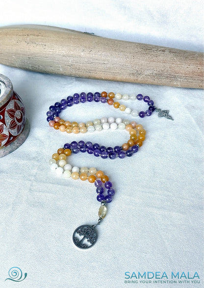 Altar display—mala necklace coiled beside selenite bowl, gemstones for growth and clarity for Sagittarius