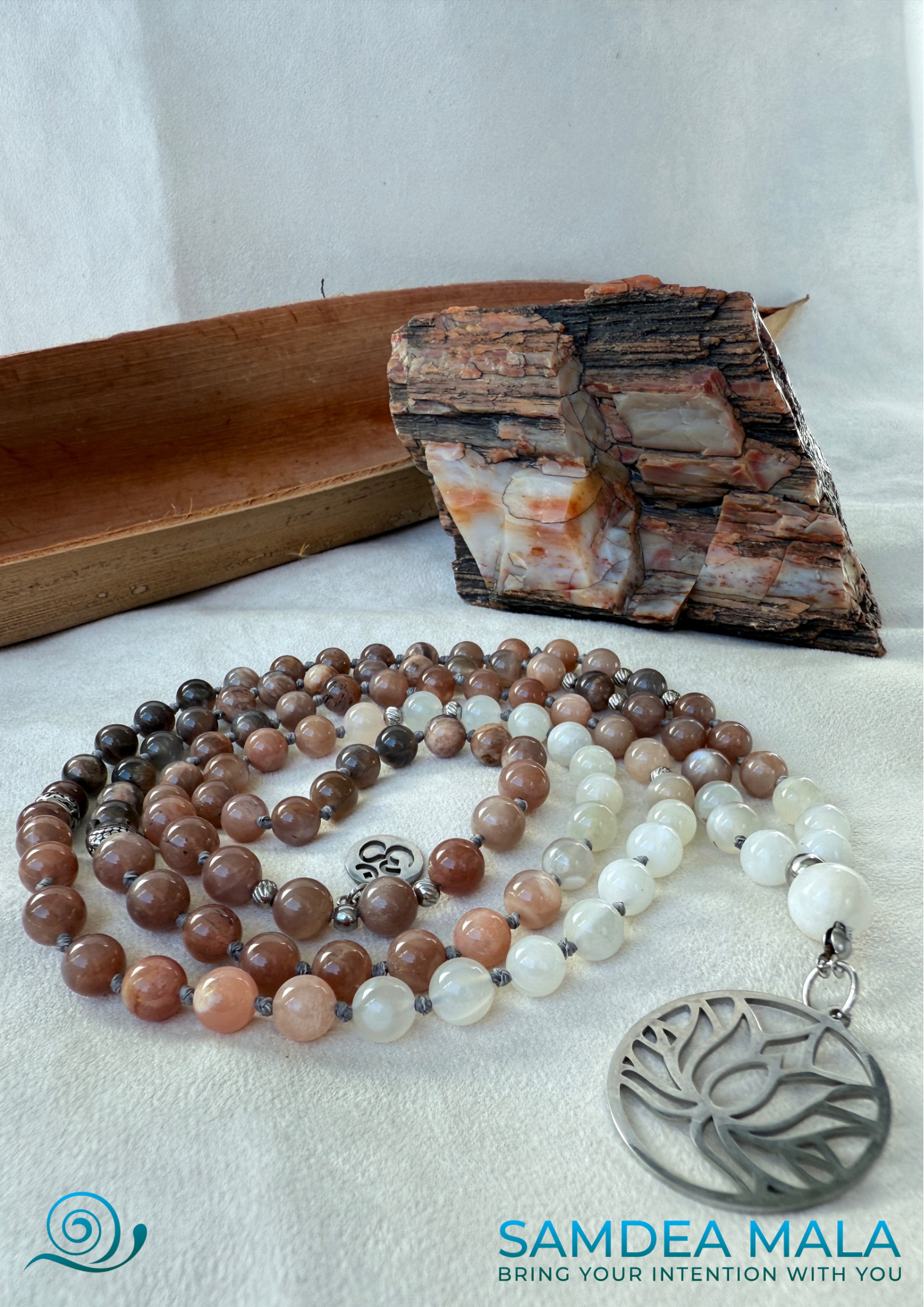 Samdea Mala - Moonstone Mala with Buddha, Lotus and OM - Feminine Energy Mala | Intuition Mala with Lotus Pendant | 108 Beads | Self-Connection & Lunar Magic. Hand knotted, handcrafted in US. 108 moonstone beads in soft pink and gray hues, Spiritual jewelry for intuition, lunar energy, and inner self-connection.