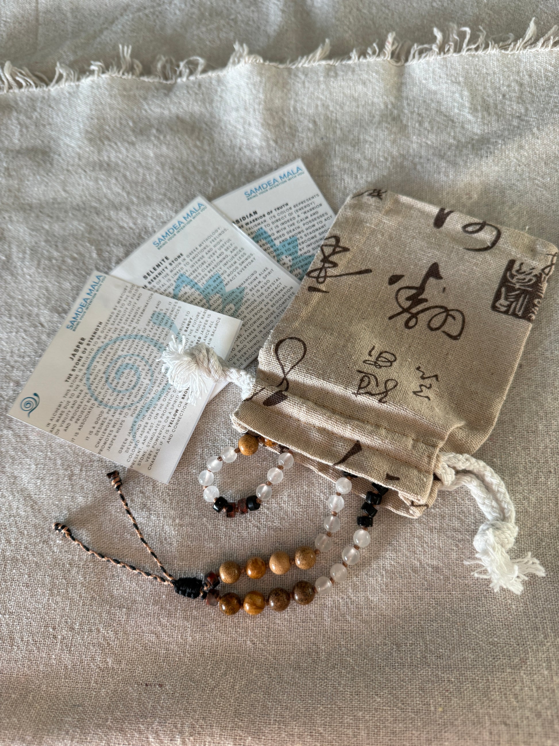 Packaging of natural gemstone Breath Mala in natural gemstones with stone descriptions and natural cotton pouch, designed to support mindful breathing and easy to carry with you every day.