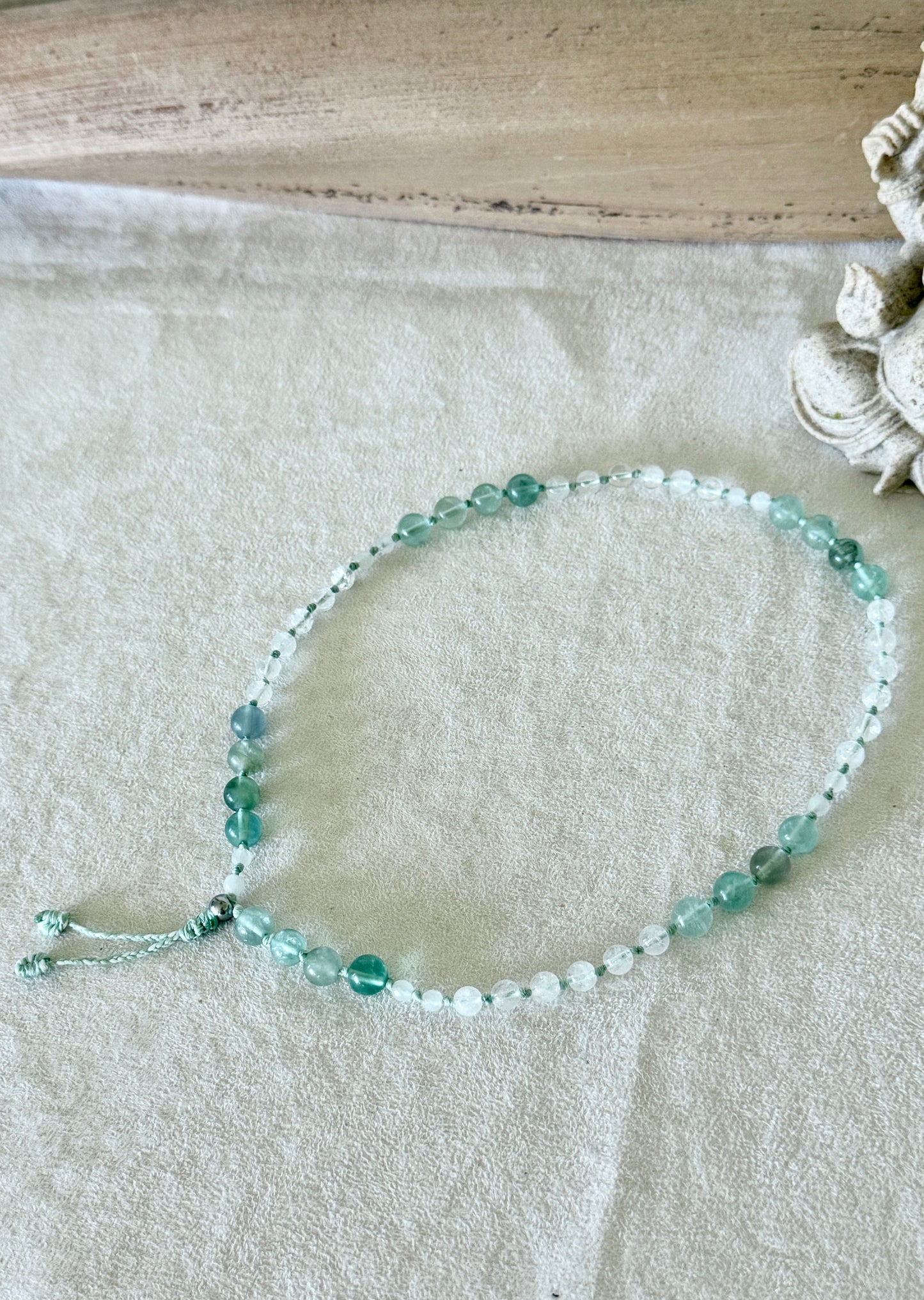Bracciale Pause Breathing Mala con grani di fluorite, giada bianca birmana e quarzo ialino, disposto a cerchio