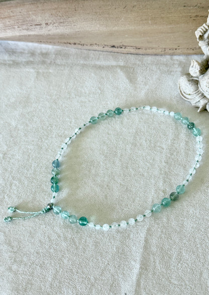 Bracciale Pause Breathing Mala con grani di fluorite, giada bianca birmana e quarzo ialino, disposto a cerchio