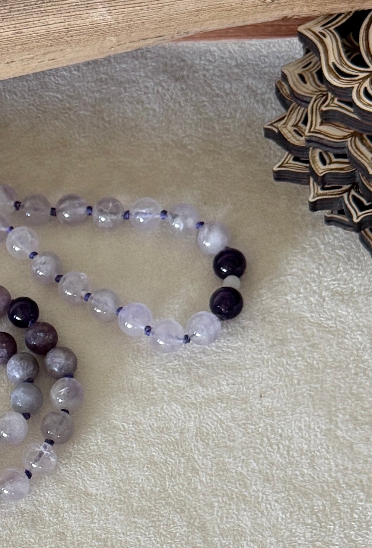Purple lavender mala necklace for meditation. Detail of white jade Bodhisattva