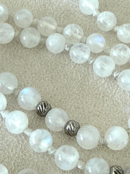 close-up of a Handmade Rainbow Moonstone mala for meditation with 108 prayer beads, 6 mm natural gemstone beads, Aqua Aura Quartz meru, stainless steel details, small lotus charm, and tassel, created for meditation, breathwork, mantra repetition, mindfulness, and intentional practice. Samdea Mala