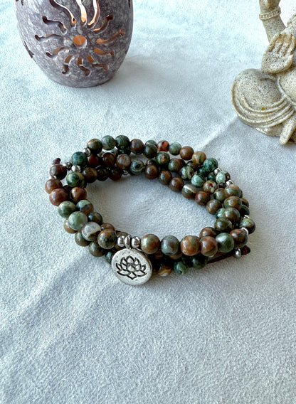 Mala Bracelet – Rhyolite Forest jasper mala bracelet with lotus charm, green and brown forest rhyolite for purity and transformation. Jewelry for grounding and spiritual reflection.