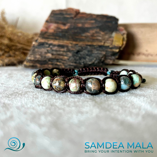 Samdea Mala Tibetan bracelet in Aqua Jasper for calm and healing. A brown beaded Shamballa bracelet with green and brown stones. The bracelet is made with a knotted cord and has a simple design. 