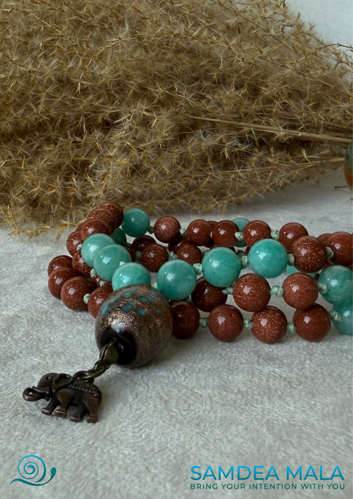 Close-up of Samdea short mala with sunstone and amazonite beads, ceramic meru and elephant charm, Spiritual necklace
