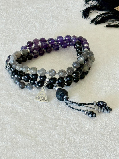 Shadow Work Mini Mala with 108 natural 6mm gemstone beads in obsidian, amethyst, and labradorite, finished with a black tassel and silver Triquetra charm by Samdea