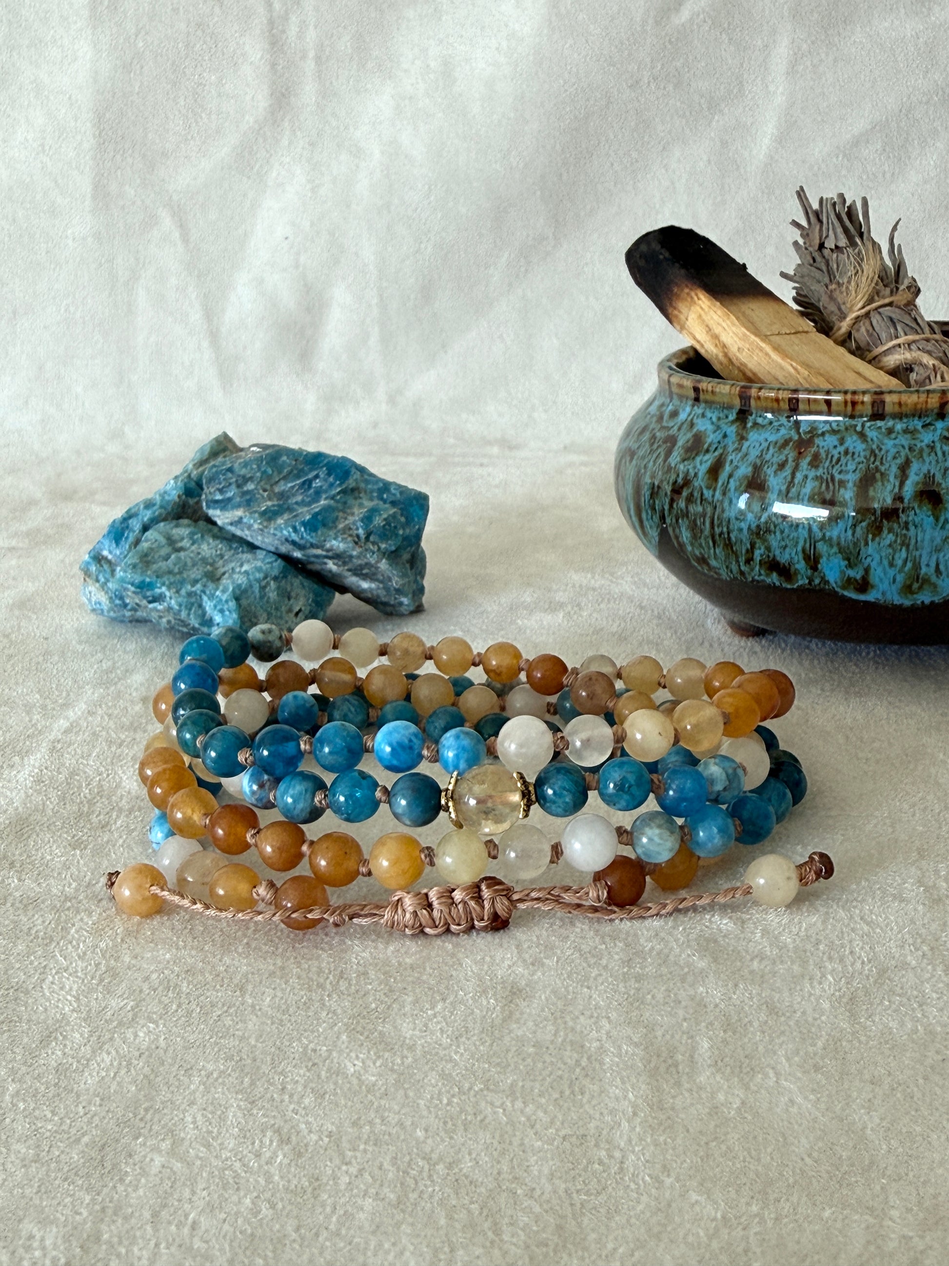 The Sun and the sea natural gemstone mala bracelet. Handmade Apatite and Yellow Jade mala bracelet with natural 6 mm gemstones, Citrine guru bead, adjustable macramé closure, and stainless steel details; a 108 bead mala necklace inspired by sea and sun, water and fire, for meditation, yoga, and intention practice.