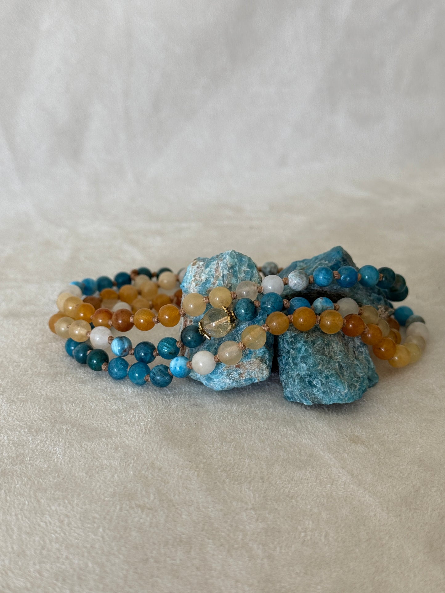 The Sun and the sea natural gemstone mala bracelet. Handmade Apatite and Yellow Jade mala bracelet with natural 6 mm gemstones, Citrine guru bead, adjustable macramé closure, and stainless steel details; a 108 bead mala necklace inspired by sea and sun, water and fire, for meditation, yoga, and intention practice.