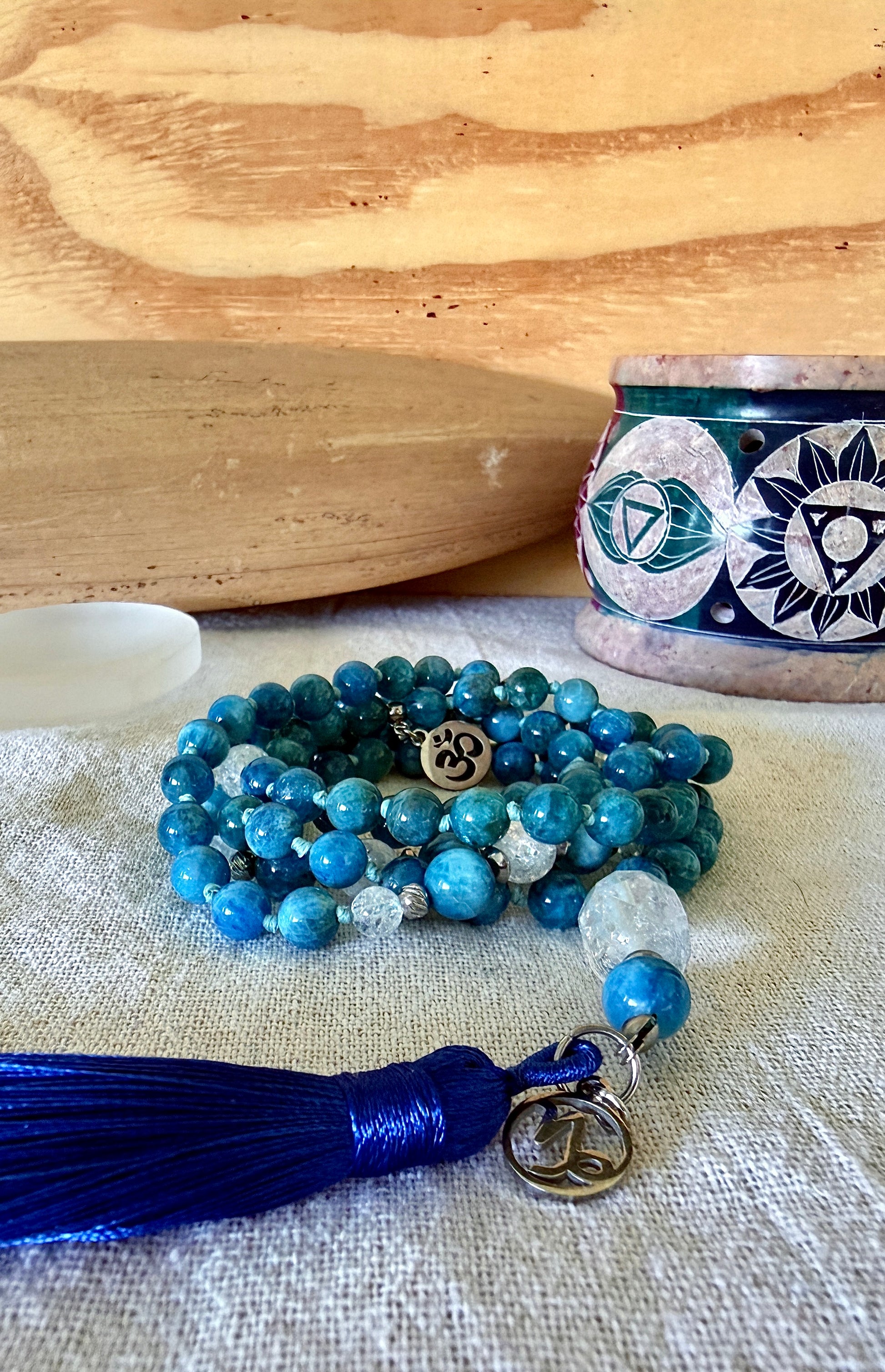 close-up of handmade mala in natural apatite for self confidence and appetite regulation - custom mala beads, OM charm, blue teal spiritual mala with tassel - prayer beads for meditation and mindfulness