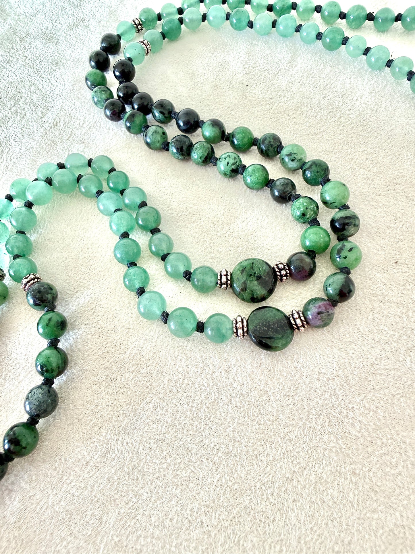 close-up of zoisite with ruby green mala bracelet with 100% natural gemstones, stainless steel turtle charm, adjustable macramé closure, and 108 bead mala necklace design for yoga, meditation, gentle growth, protection, and spiritual transformation. 