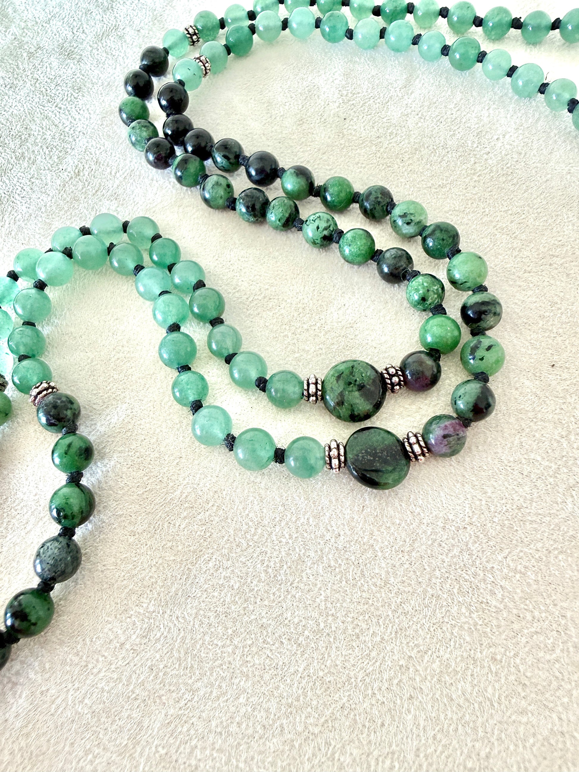 close-up of zoisite with ruby green mala bracelet with 100% natural gemstones, stainless steel turtle charm, adjustable macramé closure, and 108 bead mala necklace design for yoga, meditation, gentle growth, protection, and spiritual transformation. 