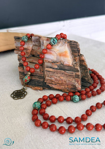 detail fo seeds of life pendant on a mala beads with Red Jasper and African Turquoise, hand-knotted with 108 beads for meditation and personal growth. Earthy red and green tones, spiritual jewelry for grounding, strength, and transformation.
