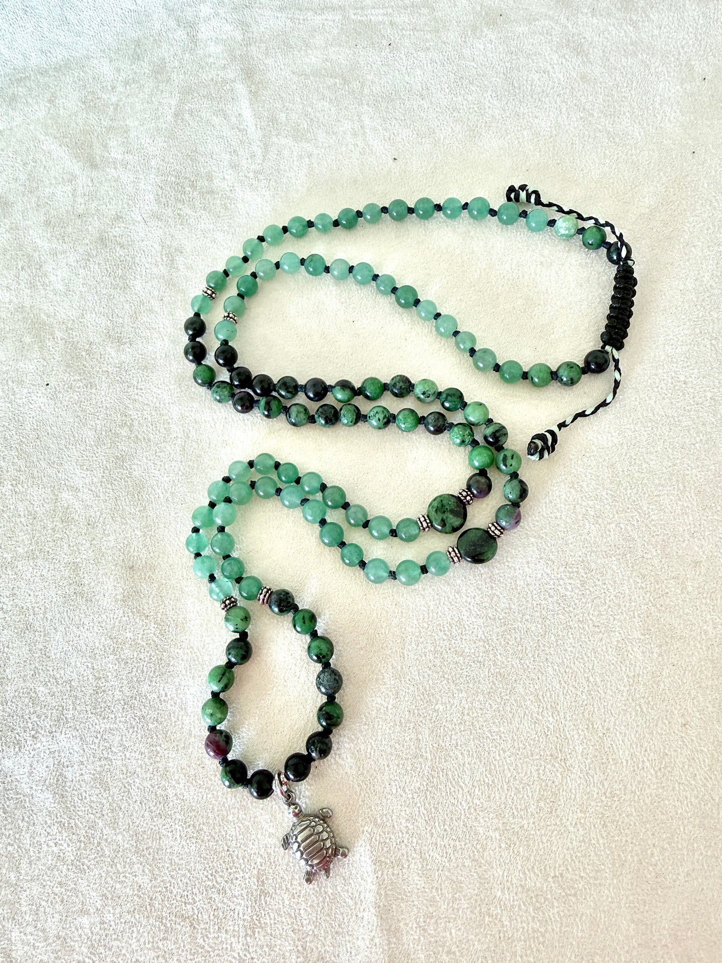 full view of green mala bracelet with 100% natural gemstones, stainless steel turtle charm, adjustable macramé closure, and 108 bead mala necklace design for yoga, meditation, gentle growth, protection, and spiritual transformation. 