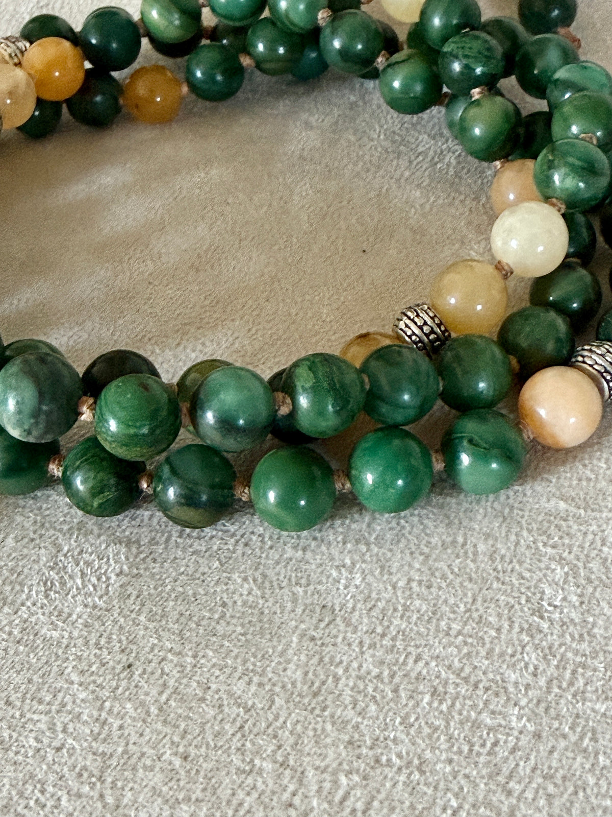 green and yellow jade - close up of mala beads for meditation