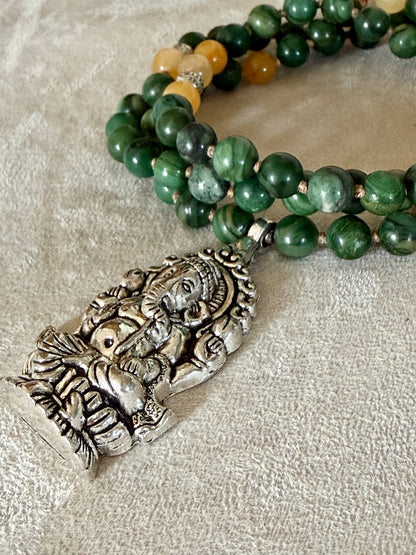 Detail of Ganesh pendant for abundance on a short green and yellow mala for every day meditation