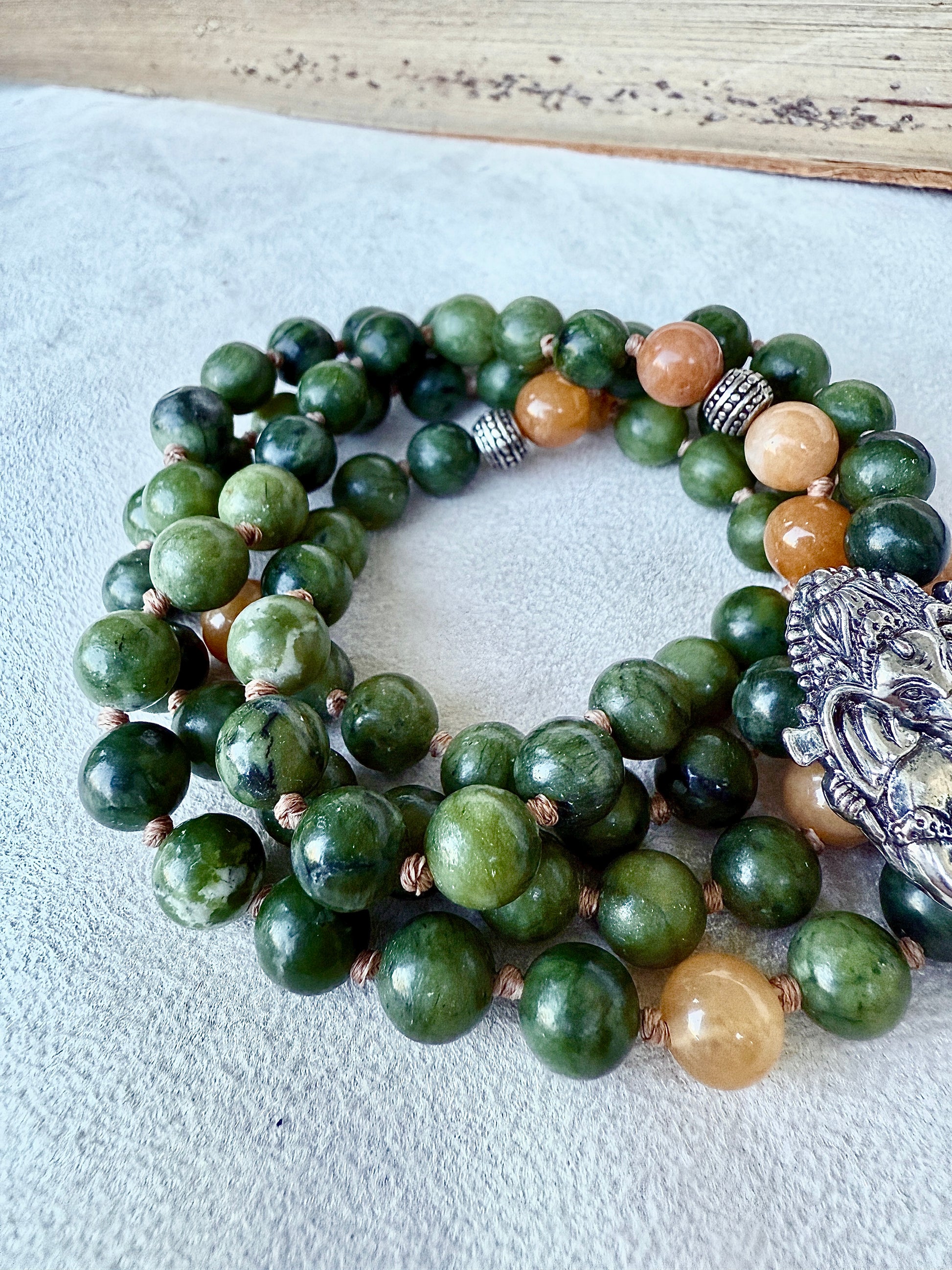 Close-up of green jade beads showing natural marbling on hand-knotted cord