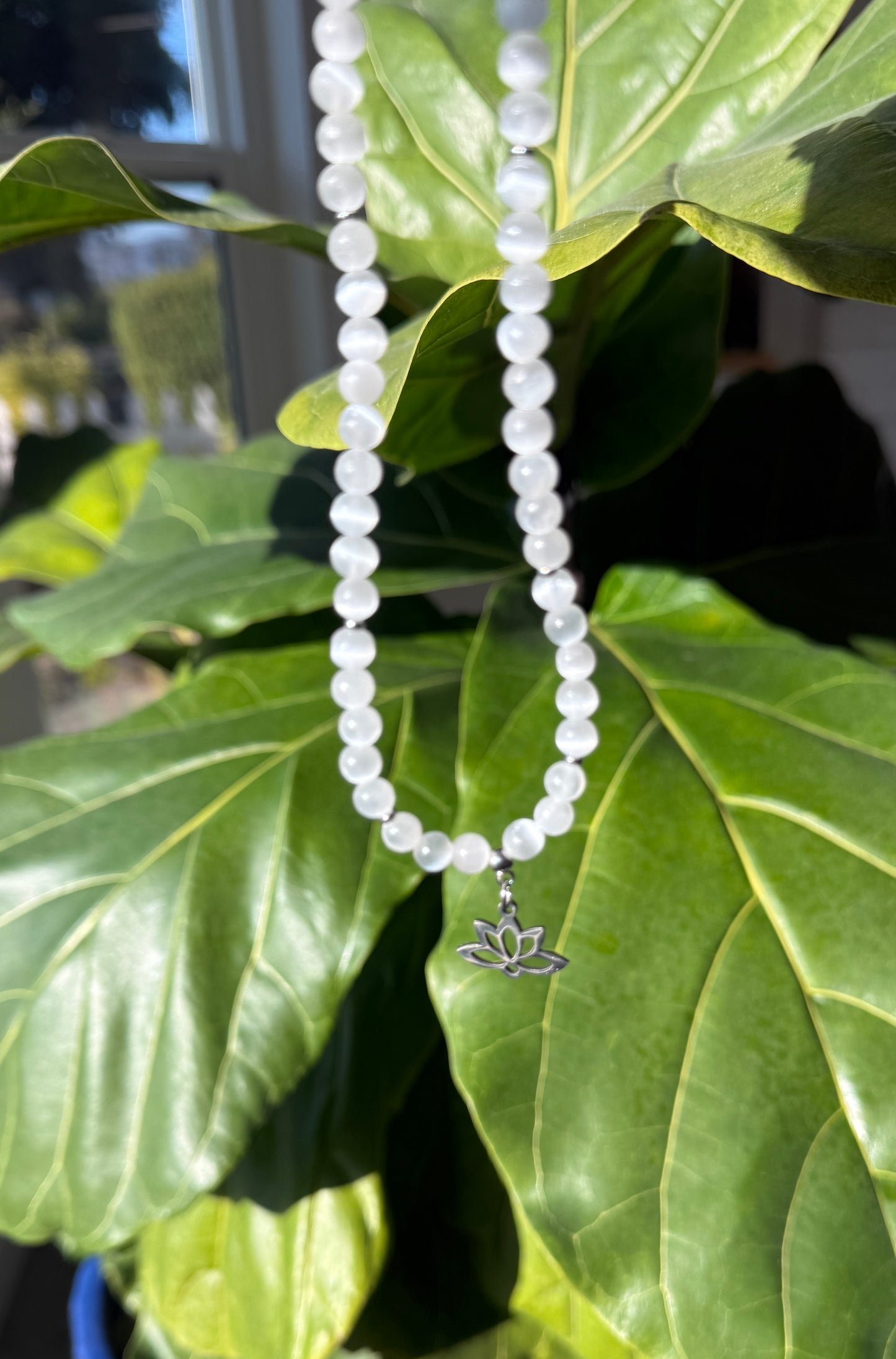 Spiritual selenite and lotus choker necklace worn as a talisman for purity and higher connection. Small lotus charm stainless steel.