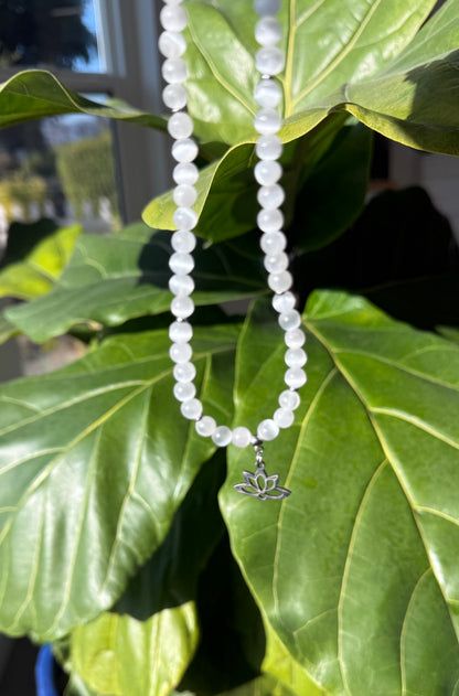 Spiritual selenite and lotus choker necklace worn as a talisman for purity and higher connection. Small lotus charm stainless steel.