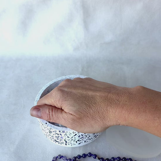 Close-up of Video featuring a bowl with natural clear quartz and amethyst crystals for energy cleansing of mala beads