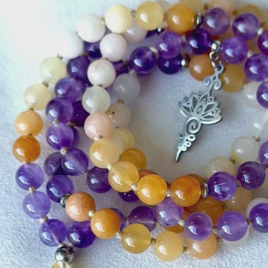 Video: mala beads moving in hand—amethyst shimmer, golden jade warmth, citrine meru sparkle