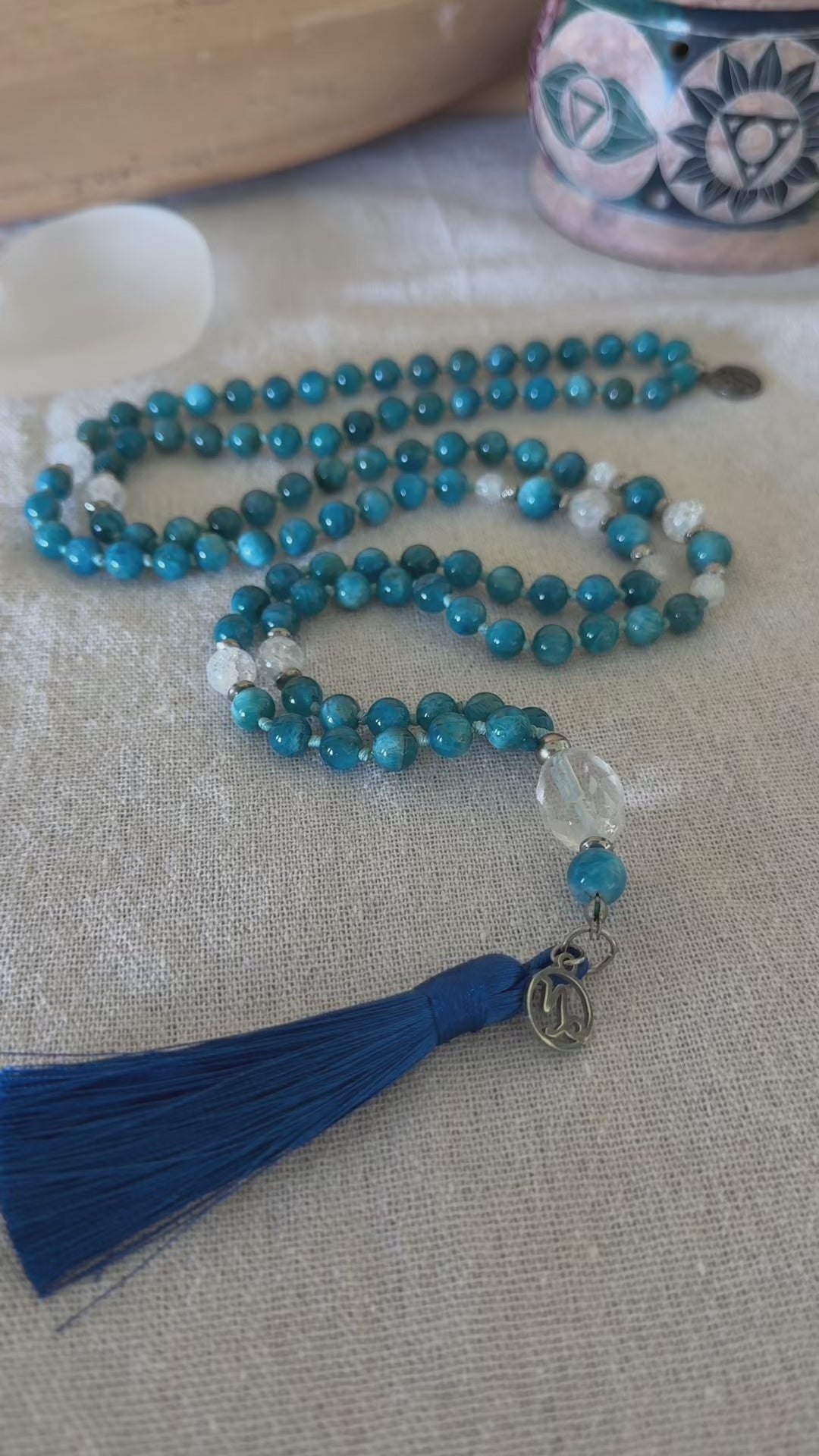 video preview of handmade mala in natural apatite for self confidence and appetite regulation - custom mala beads, OM charm, blue teal spiritual mala with tassel - prayer beads for meditation and mindfulness