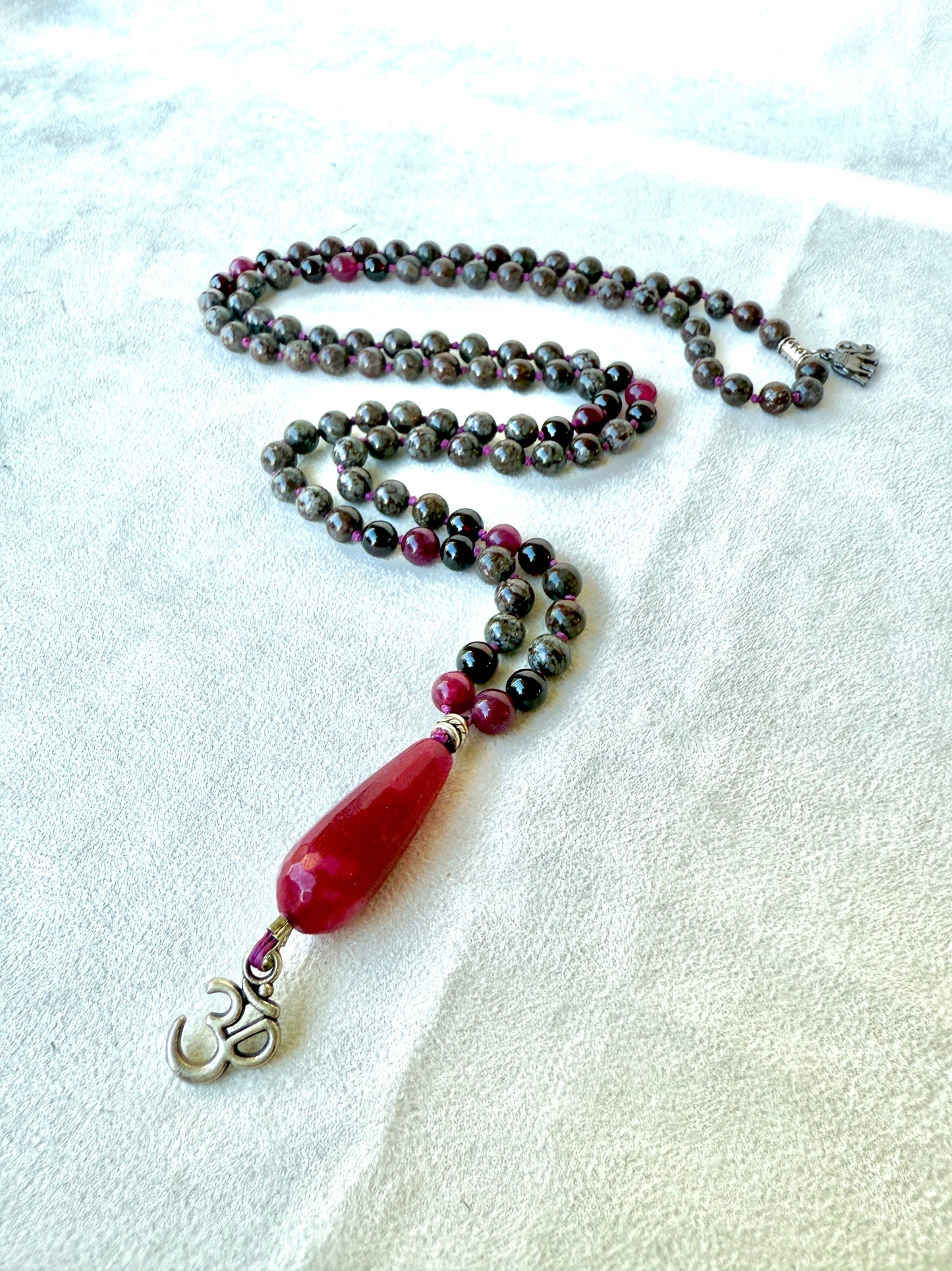 Flat lay: mala beside selenite bowl, spiritual jewelry for cleansing and intention