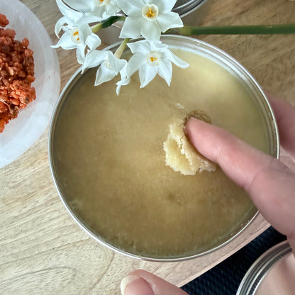 Hands scooping sugar scrub, water-free body exfoliator